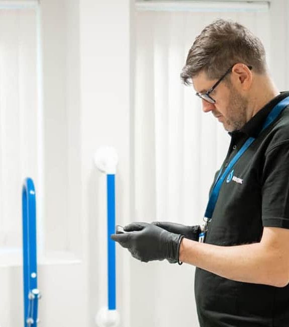 Engineer carrying out Legionella training demonstration in a washroom environment