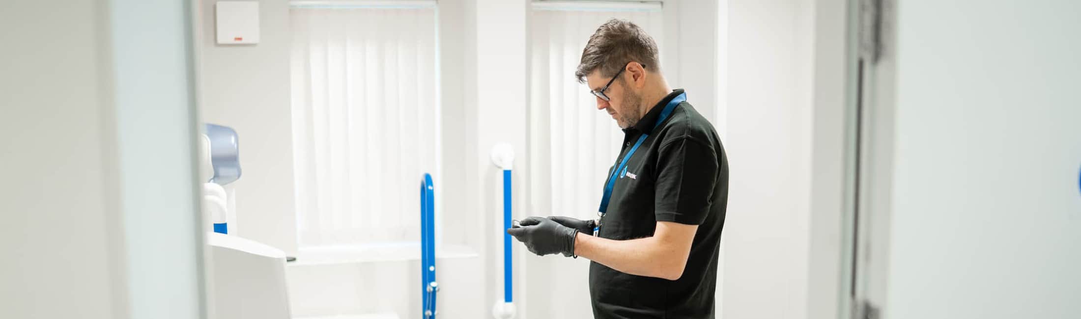 Engineer carrying out Legionella training demonstration in a washroom environment